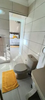 a bathroom with a toilet and a sink and a bed at The Dream Guesthouse in Ermelo