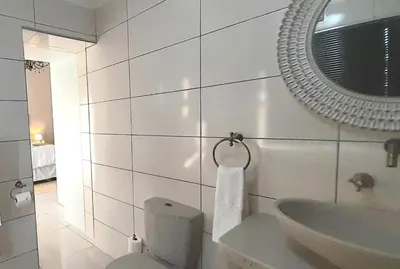 a bathroom with a sink and a toilet and a mirror at The Dream Guesthouse in Ermelo