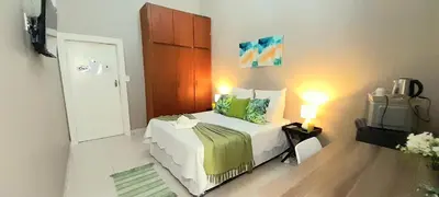 a small bedroom with a bed and a television at The Dream Guesthouse in Ermelo