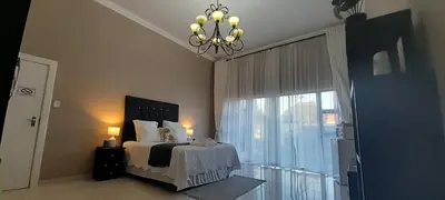 a bedroom with a bed and a large window at The Dream Guesthouse in Ermelo