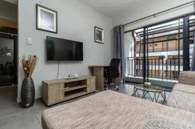 a living room with a flat screen tv and a couch at Smart apartment 322 in Midrand