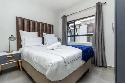 a bedroom with a large bed and a window at Smart apartment 322 in Midrand