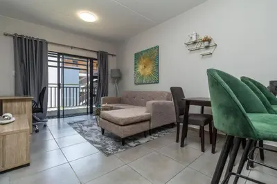 a living room with a couch and a table at Smart apartment 322 in Midrand