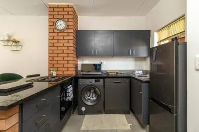 a kitchen with a washing machine and a refrigerator at Smart apartment 322 in Midrand