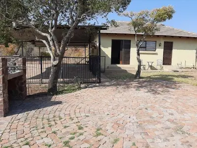 a house with a fence and a brick driveway at Matalatala Wildlife Lodge in Roodeplaat