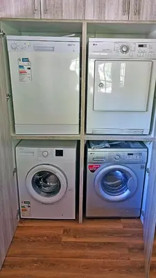 three washing machines and a washer and dryer in a room at Loskop Serene Bush Cabin in Winterkamp