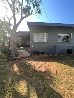 a house with a tree in front of it at Palm House Accomodation in White River