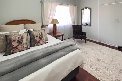a bedroom with a large bed with pillows on it at Palm House Accomodation in White River