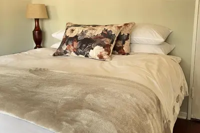 a bed with a pillow on top of it at Palm House Accomodation in White River