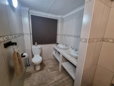 a bathroom with a toilet and a sink and a mirror at Hoep Hoep Self Catering in Groblersdal