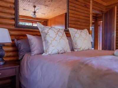 a bedroom with a bed in a log cabin at Moopong Farm House in Dullstroom