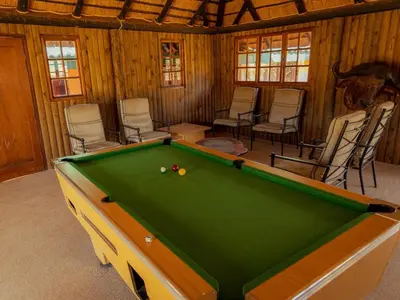 a pool table in a room with chairs at Moopong Farm House in Dullstroom