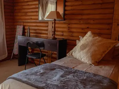 a bedroom with a bed and a desk and a chair at Moopong Farm House in Dullstroom