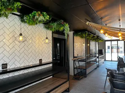 a bar with potted plants on the wall at Riverleaf Hotel in Brits