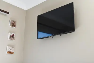 a flat screen tv hanging on a wall at Falcons Rest in Pretoria