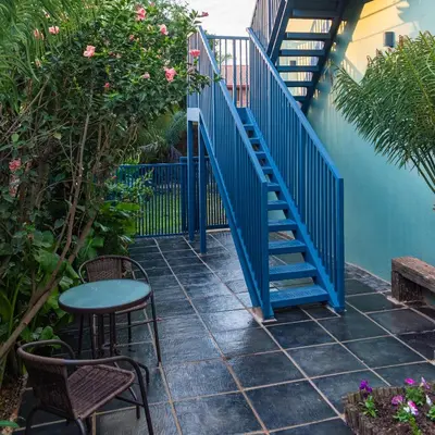 a blue stairway with a table and a table and chairs at Falcons Rest in Pretoria