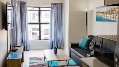 a living room with a couch and a large window at 1368 The Blyde Crystal Clear 1 Bedroom Apartment in Pretoria