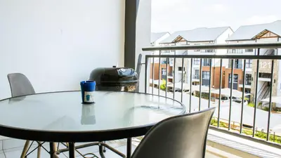 a table and chairs on a balcony with a view of a building at 1368 The Blyde Crystal Clear 1 Bedroom Apartment in Pretoria