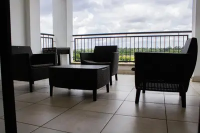 a room with chairs and a table and a balcony at 5 The Blyde Crystal Clear 2 Bedroom Apartment in Pretoria