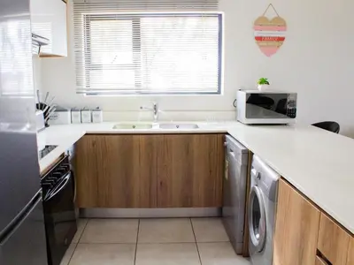 a kitchen with a sink and a microwave at 5 The Blyde Crystal Clear 2 Bedroom Apartment in Pretoria