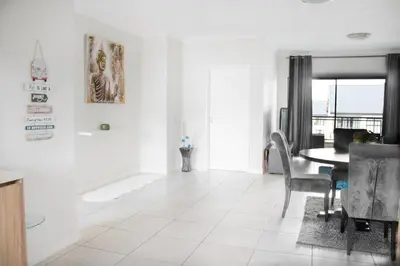 a white living room with a table and chairs at 507 The Blyde Crystal Clear Lagoon 2 Bedroom Apartment in Pretoria
