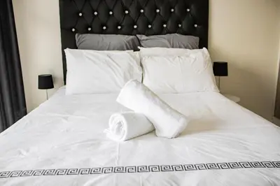 a white bed with a roll of towels on it at 507 The Blyde Crystal Clear Lagoon 2 Bedroom Apartment in Pretoria