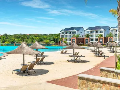a beach with chairs and umbrellas and a pool at 1523 The Blyde Crystal Clear 2 Bedroom Apartment in Pretoria