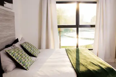 a bed with two pillows in front of a window at 1523 The Blyde Crystal Clear 2 Bedroom Apartment in Pretoria