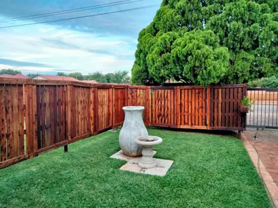 a large vase sitting on the grass near a fence at At Home Apartments in Mokopane