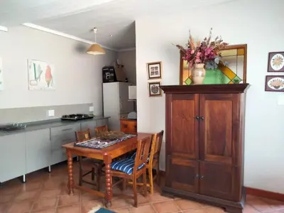 a kitchen with a wooden table and a dining room at At Home Apartments in Mokopane