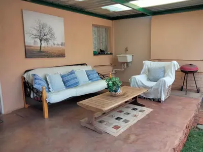 a living room with a couch and a table and a chair at At Home Apartments in Mokopane