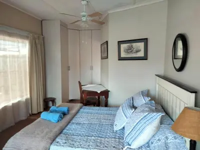 a bedroom with a large bed with blue pillows at At Home Apartments in Mokopane