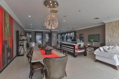a living room with a table and chairs and a couch at The Pecan Lake Guesthouse in Hartbeespoort