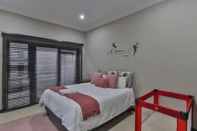 a bedroom with a large bed and a window at The Pecan Lake Guesthouse in Hartbeespoort