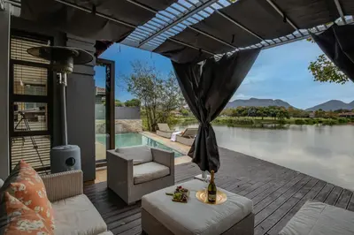 a patio with a view of a body of water at The Pecan Lake Guesthouse in Hartbeespoort