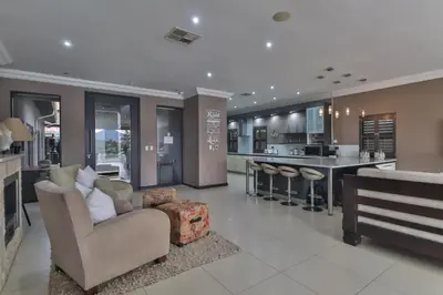 a kitchen and living room with a couch and a bar at The Pecan Lake Guesthouse in Hartbeespoort