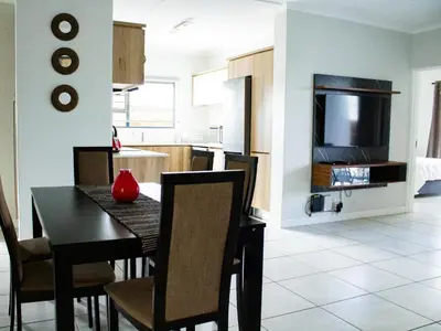 a dining room and kitchen with a table and chairs at 1253 The Blyde Crystal Clear 3 Bedroom Garden Apartment in Pretoria