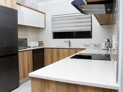 a kitchen with white counter tops and wooden cabinets at 1254 The Blyde Crystal Clear 3 Bedroom Garden Apartment in Pretoria