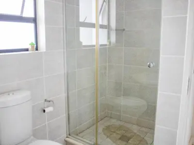 a shower with a glass door next to a toilet at 1254 The Blyde Crystal Clear 3 Bedroom Garden Apartment in Pretoria