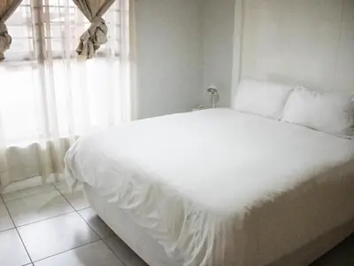 a white bed in a room with a window at 1254 The Blyde Crystal Clear 3 Bedroom Garden Apartment in Pretoria