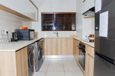a kitchen with a washer and dryer and a sink at 1517 The Blyde Crystal Clear 3 Bedroom Garden Beachfront in Pretoria