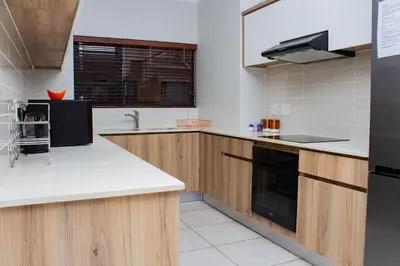 a kitchen with white counter tops and wooden cabinets at 1517 The Blyde Crystal Clear 3 Bedroom Garden Beachfront in Pretoria