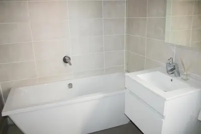 a bathroom with a white tub and a sink at 1517 The Blyde Crystal Clear 3 Bedroom Garden Beachfront in Pretoria