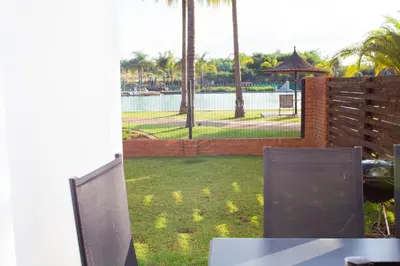 a patio with a fence and a view of a park at 1517 The Blyde Crystal Clear 3 Bedroom Garden Beachfront in Pretoria