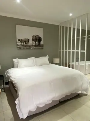 a bedroom with a large white bed with a picture of animals at The Meander Estate in Balmoral