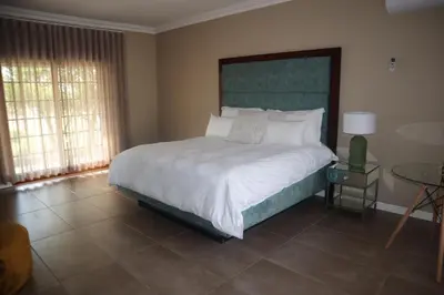 a bedroom with a large bed and a table at The Meander Estate in Balmoral