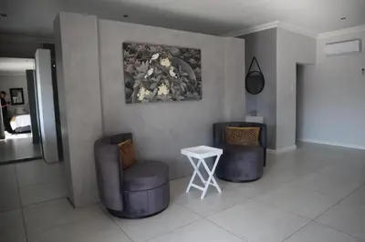 a room with two chairs and a table and a painting at The Meander Estate in Balmoral