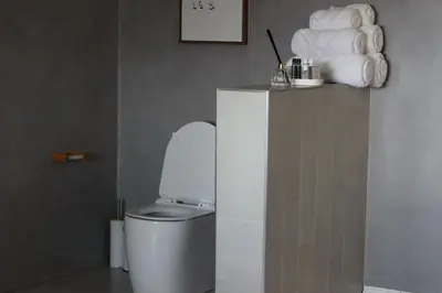 a bathroom with a toilet and a pile of towels at The Meander Estate in Balmoral