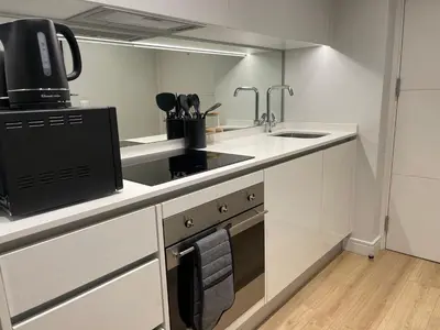a white kitchen with a sink and a stove at Exec Oasis @Ellipse in Midrand