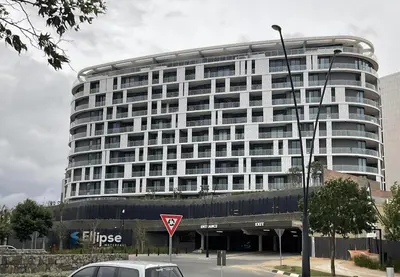 a large building with a car parked in front of it at Exec Oasis @Ellipse in Midrand